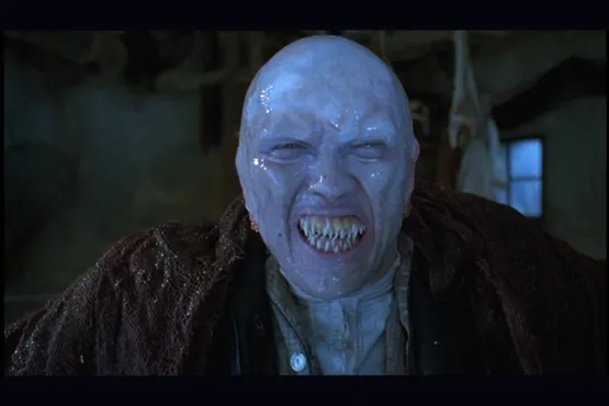 Mutant à la peau luisante et dents acérées, dans une pièce sombre d’Innsmouth
