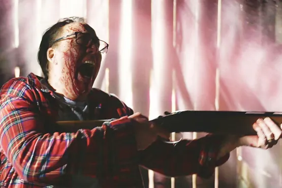 Nicolas Cage brandissant un fusil, couvert de sang dans le film Color Out of Space